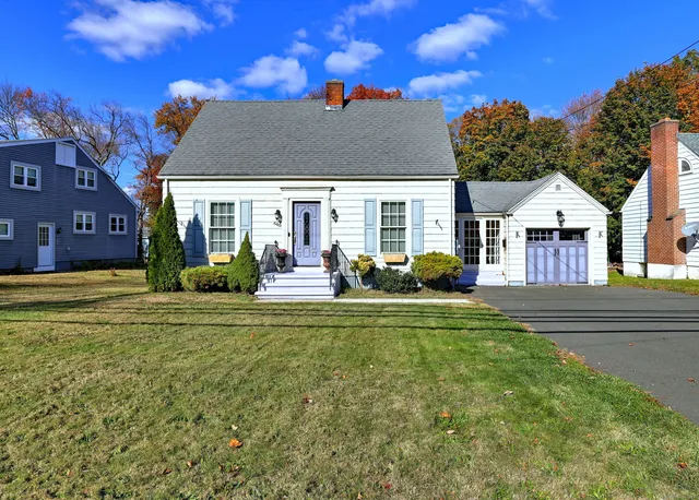 a view of a house with a big yard and potted plants