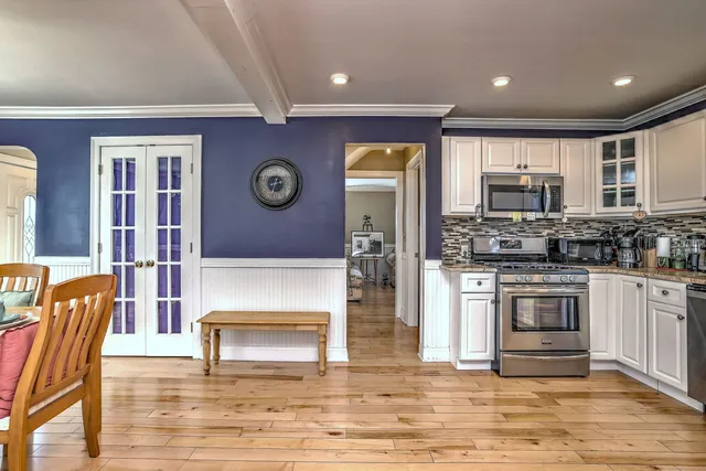 a living room with stainless steel appliances kitchen island granite countertop a stove and a refrigerator