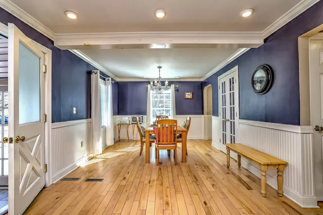 a dining room with stainless steel appliances wooden floor and chandelier