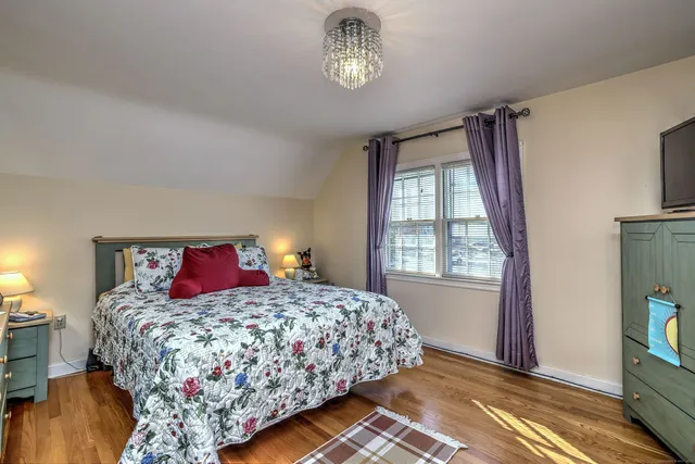 a bedroom with a large bed and a chandelier