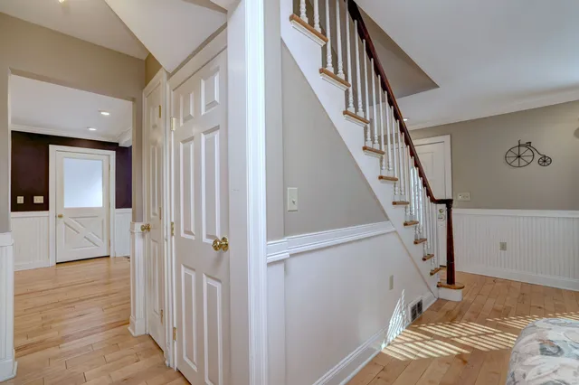 a view of a hallway with wooden floor and staircase