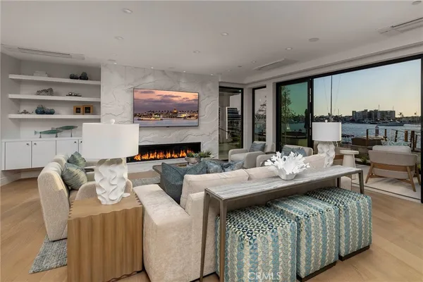 a living room with couches and kitchen view with wooden floor
