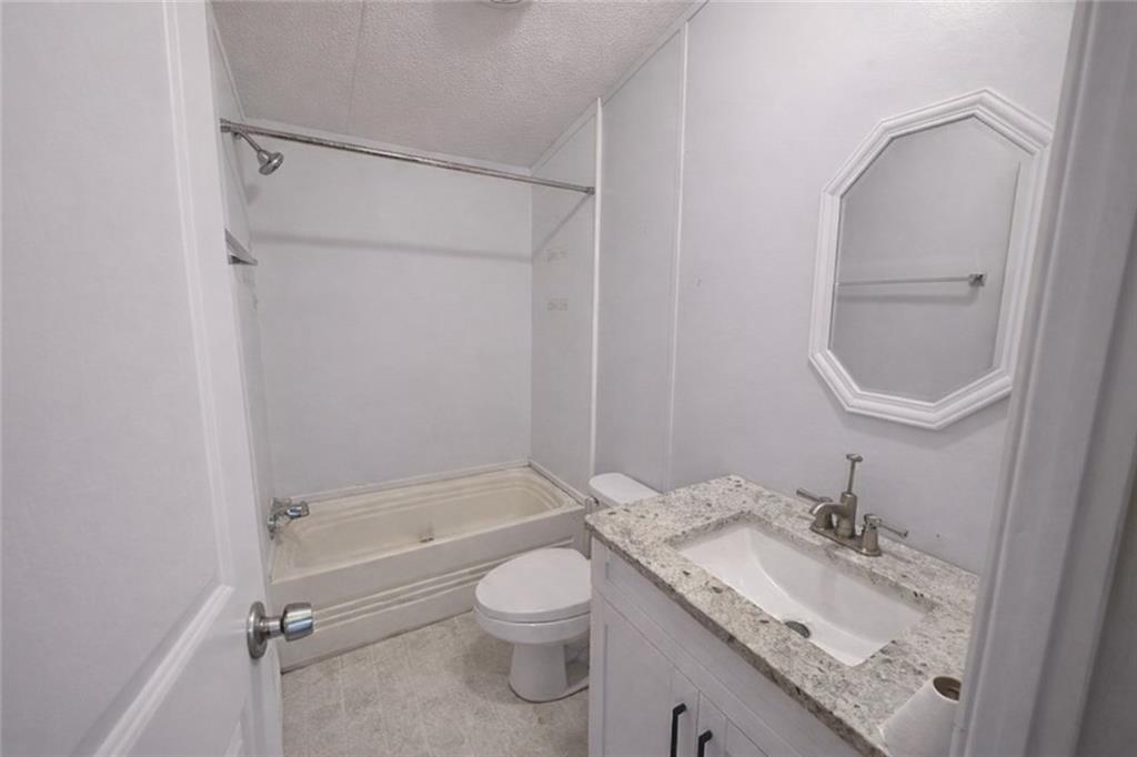 460 Cherokee Trail Ball Ground, GA 30107 - Photo 16 of 23 a bathroom with a granite countertop sink toilet and shower