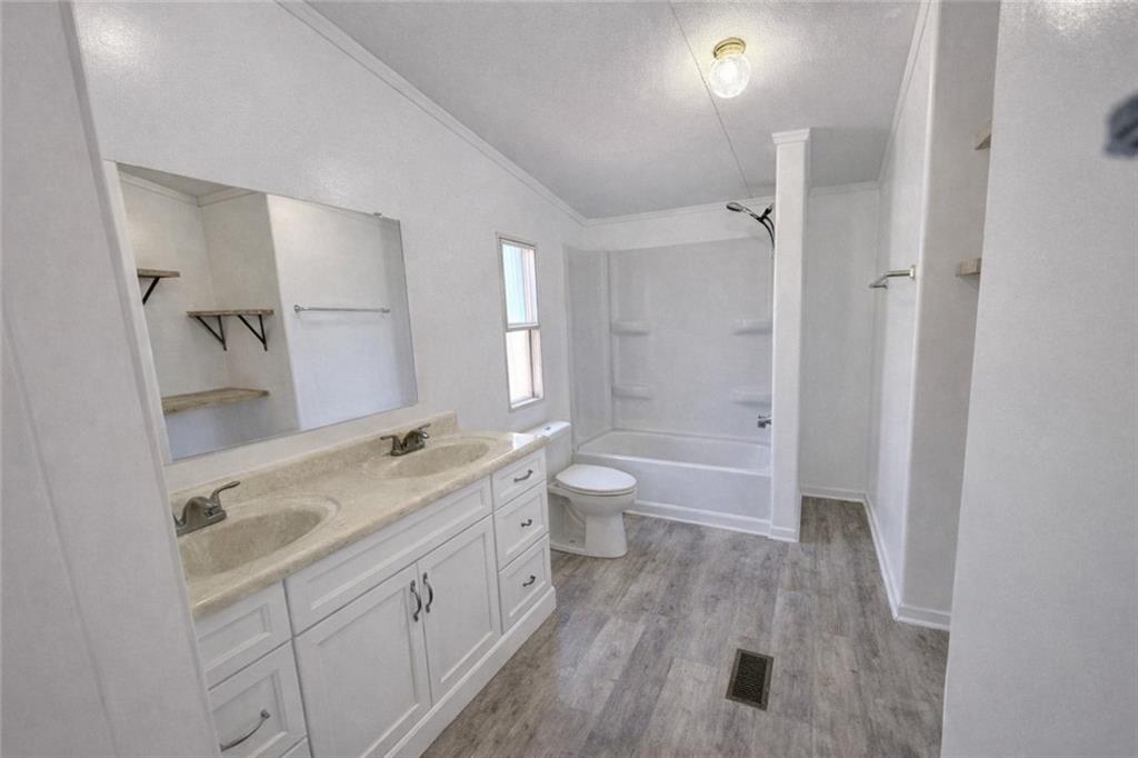 460 Cherokee Trail Ball Ground, GA 30107 - Photo 10 of 23 a spacious bathroom with a granite countertop sink a toilet and shower
