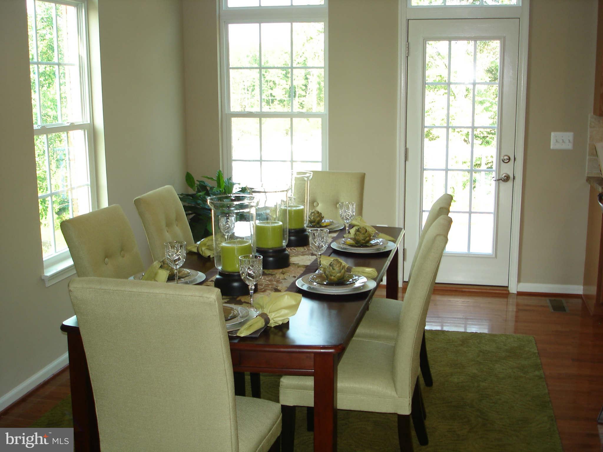 2414 Baileys Pond Road Accokeek, MD 20607 - Photo 6 of 22 a dining room with furniture a large window and wooden floor