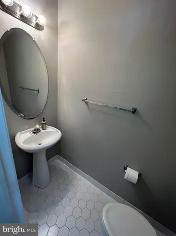 a bathroom with a sink toilet and a mirror