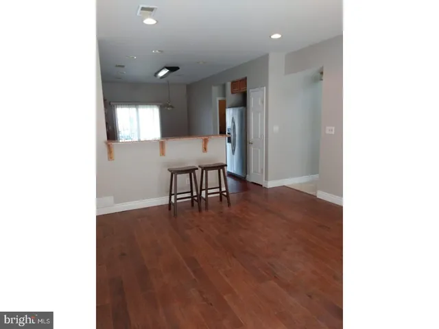 a view of a hallway with wooden floor and furniture