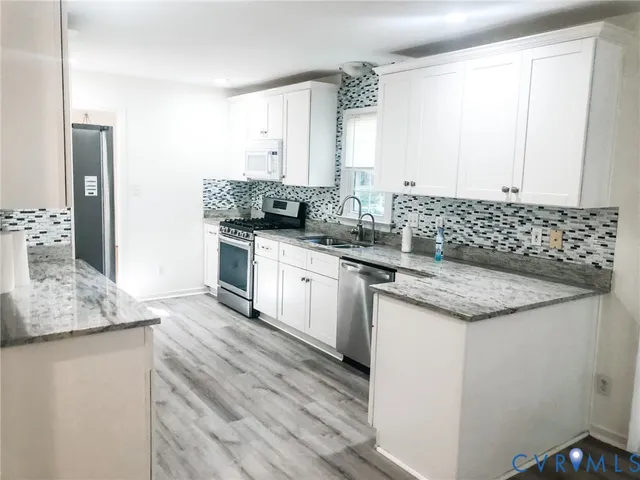 a kitchen with granite countertop a sink and a stove