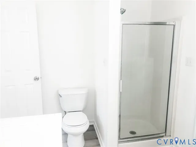 a white toilet sitting next to a shower