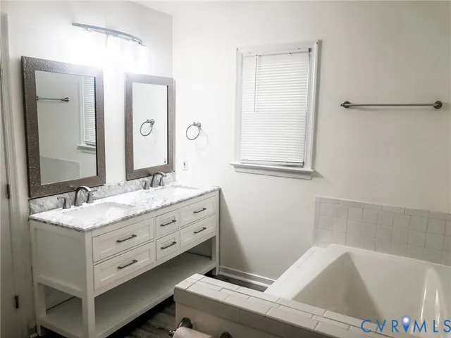a bathroom with a tub sink and mirror