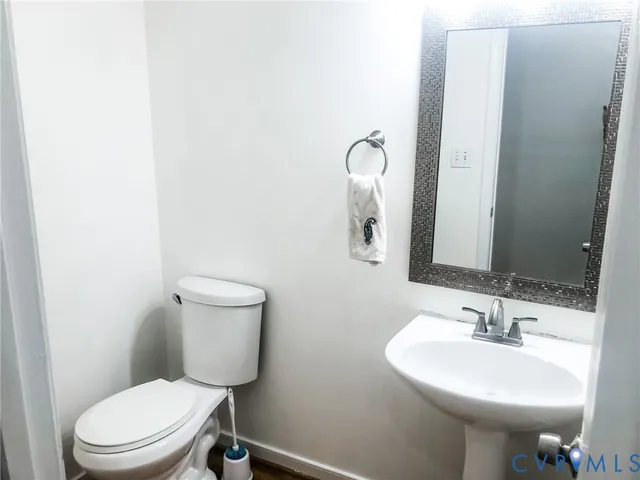 a bathroom with a toilet a sink and mirror