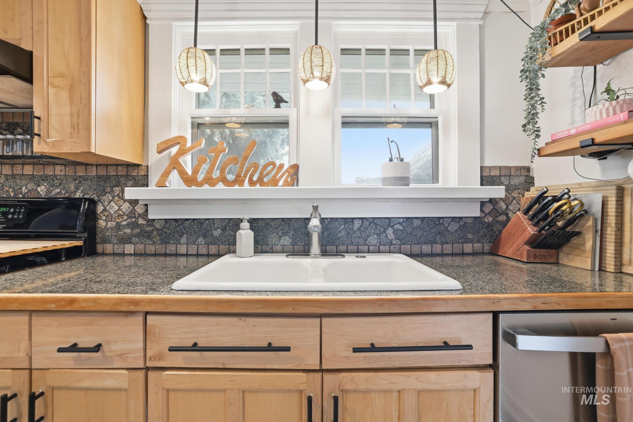 502 6th Street Filer, ID 83328 - Photo 18 of 41 Kitchen with light wood finish cabinets, decorative light fixtures, dishwasher, and black range