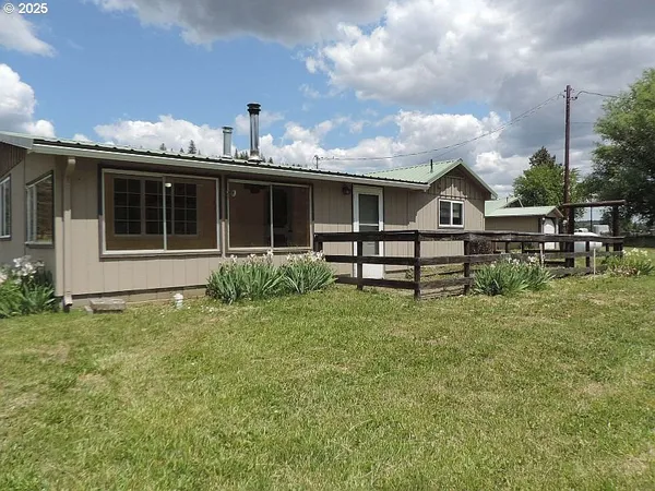 a view of a house with backyard and sitting area