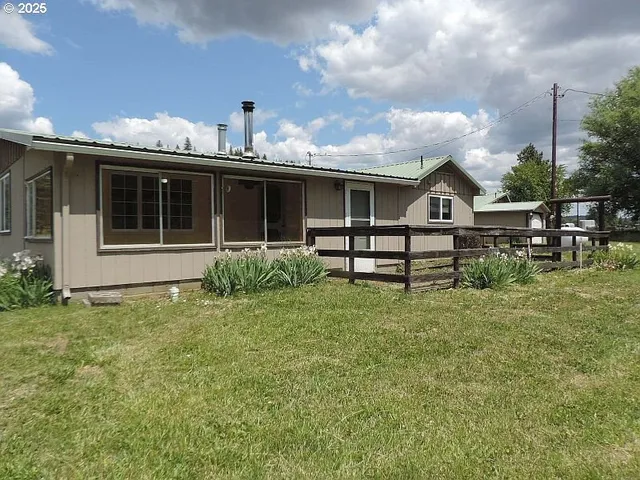 a view of a house with backyard and sitting area
