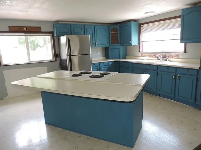 a kitchen with stainless steel appliances granite countertop a sink a microwave a window and refrigerator