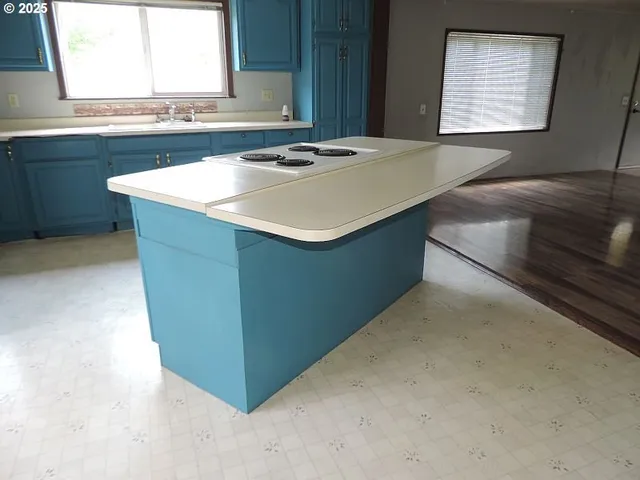 a kitchen with kitchen island sink and window
