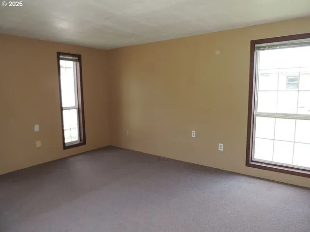 an empty room with windows and closet