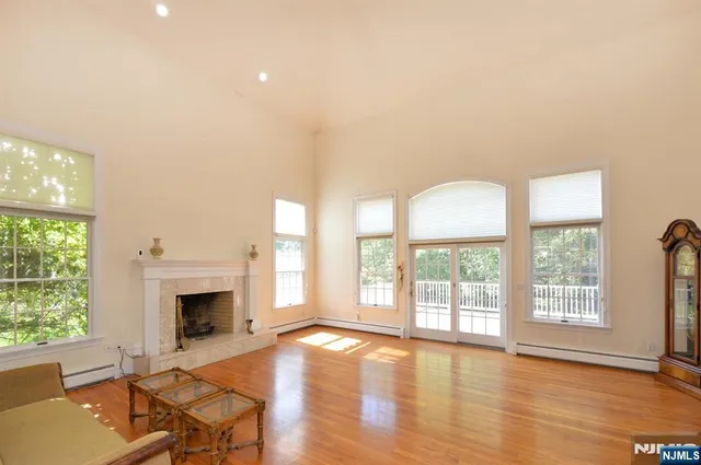 wooden floor fireplace and windows in an empty room