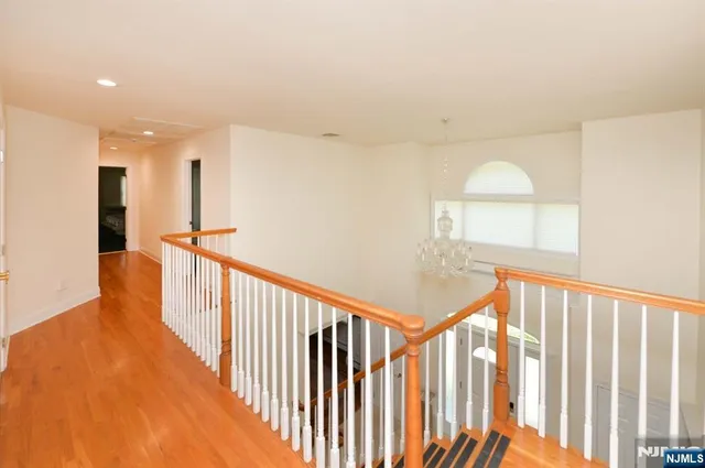a view of a hallway with wooden floor and staircase