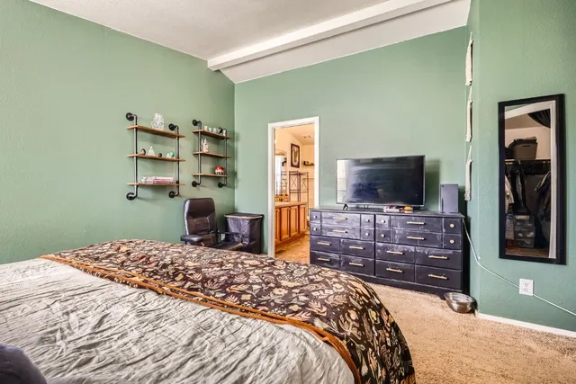 a bedroom with a bed and a flat screen tv