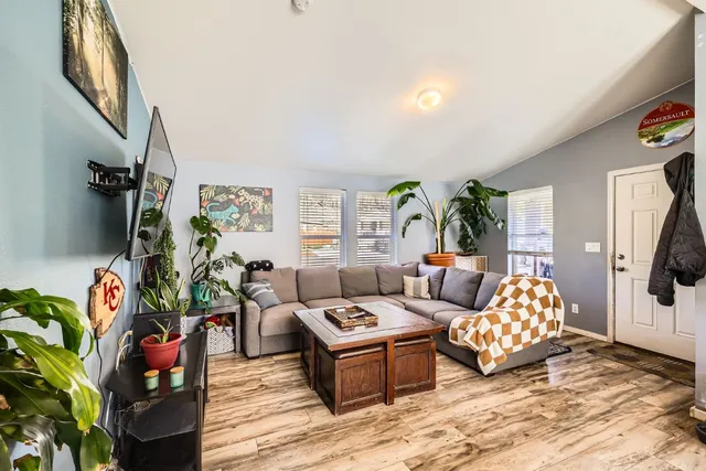 a living room with patio furniture and a potted plant