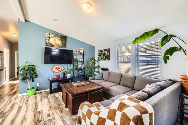 a living room with furniture a flat screen tv and a large window