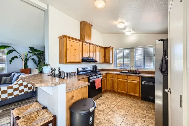 a open kitchen with stainless steel appliances granite countertop a sink stove and refrigerator