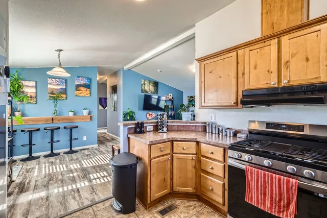 a kitchen with stainless steel appliances granite countertop a stove a sink and a cabinets