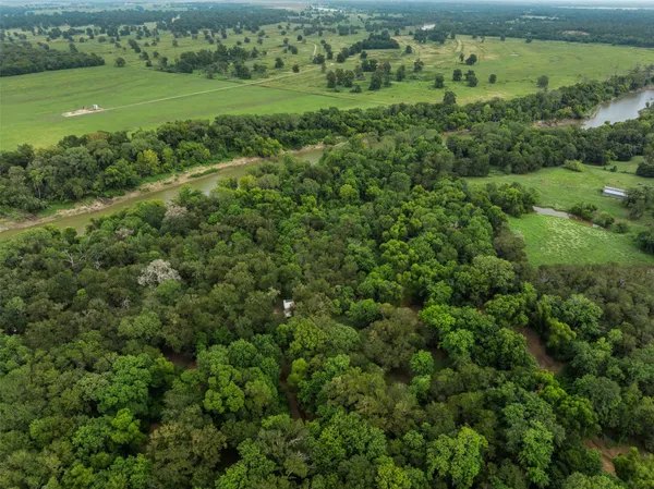 an aerial view of residential houses with outdoor space and trees