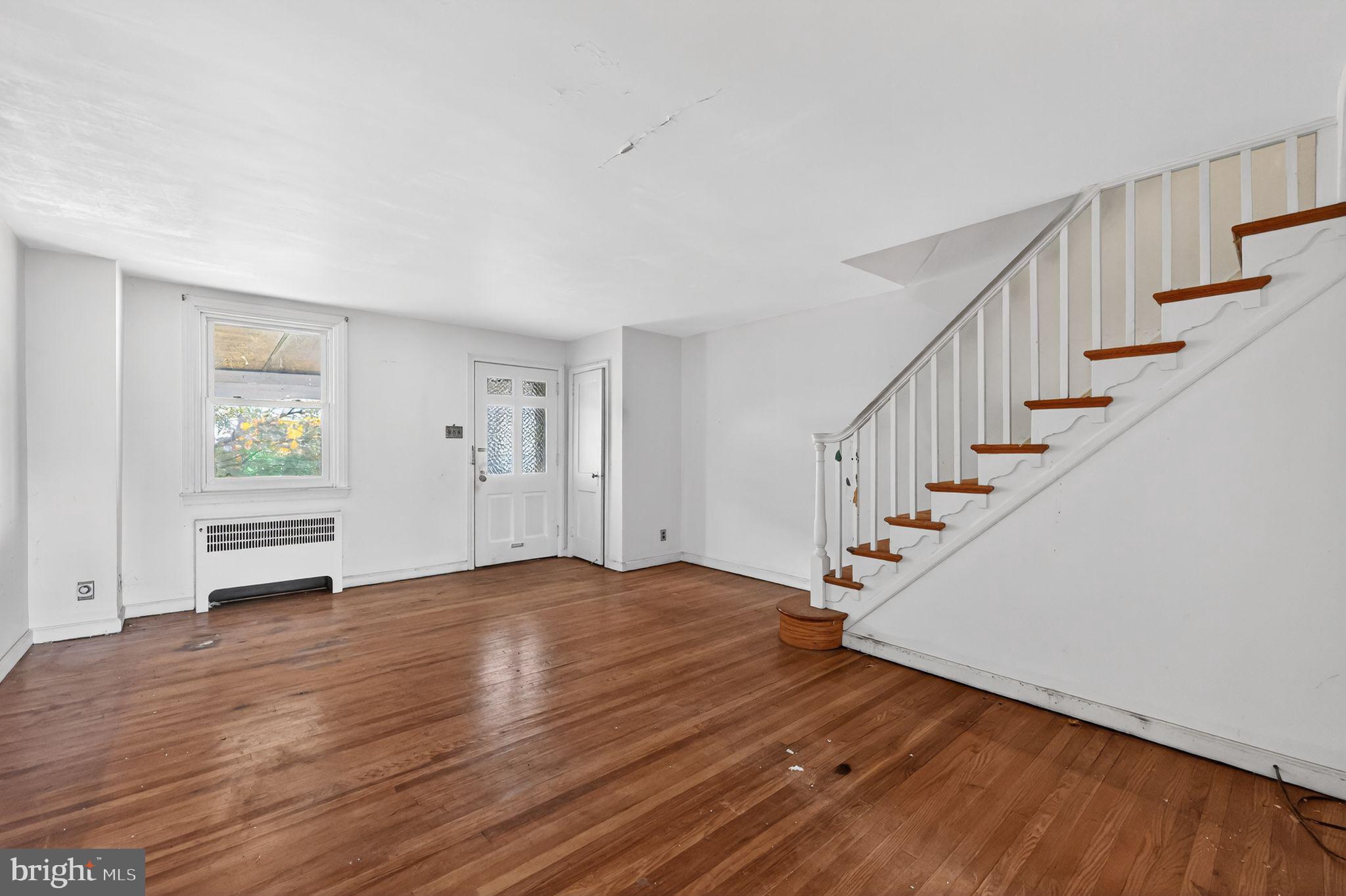 7181 Ruskin Lane Upper Darby, PA 19082 - Photo 5 of 30 a view of an empty room with wooden floor and stairs