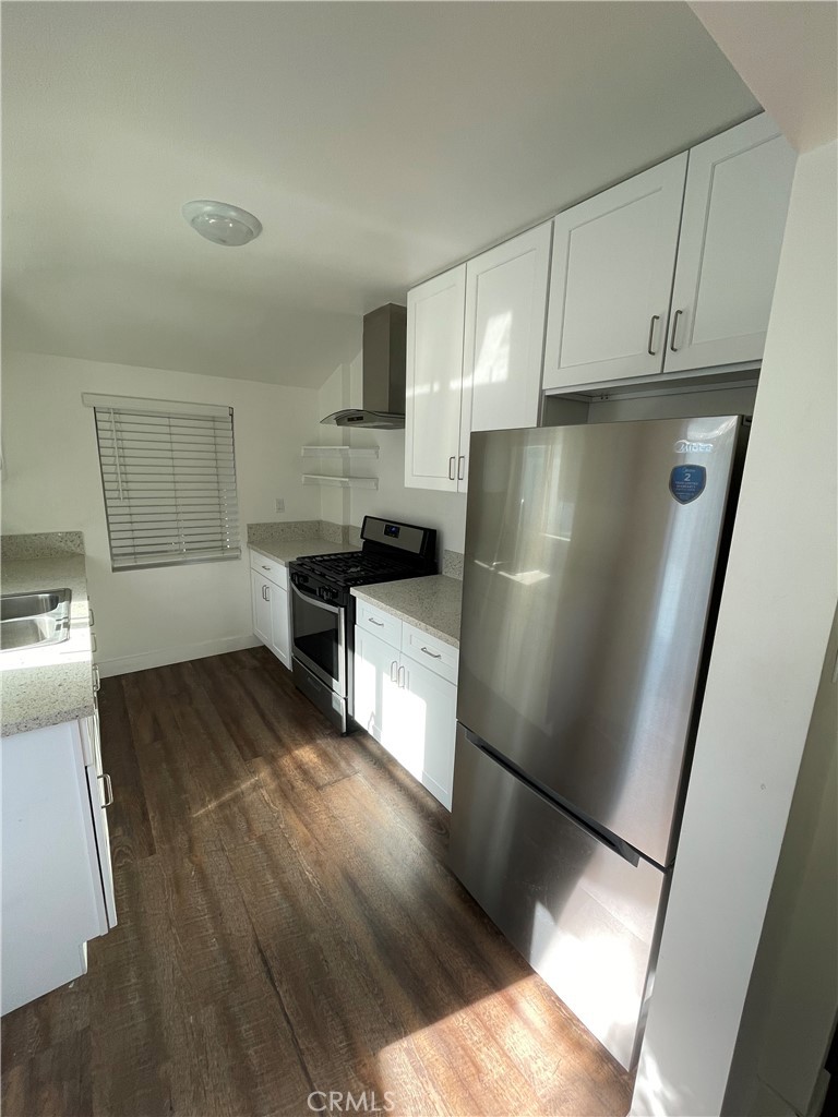8536 5th Street Downey, CA 90241 - Photo 6 of 13 a kitchen with a refrigerator sink and cabinets