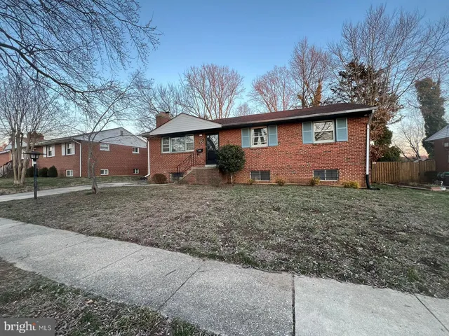 a view of a house with a backyard and large tree