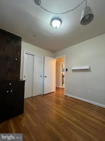 an empty room with wooden floor and window