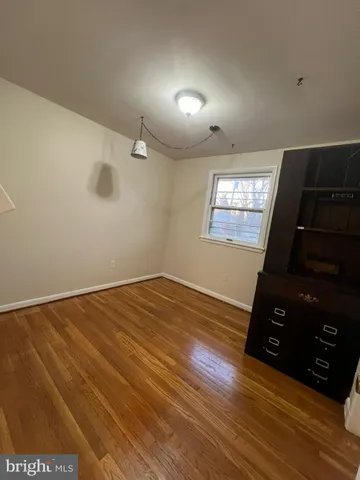 a view of a room with wooden floor and chandelier