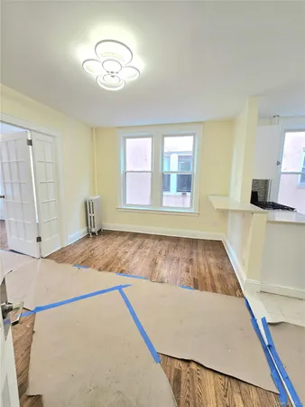 a view of a bedroom with wooden floor and a window