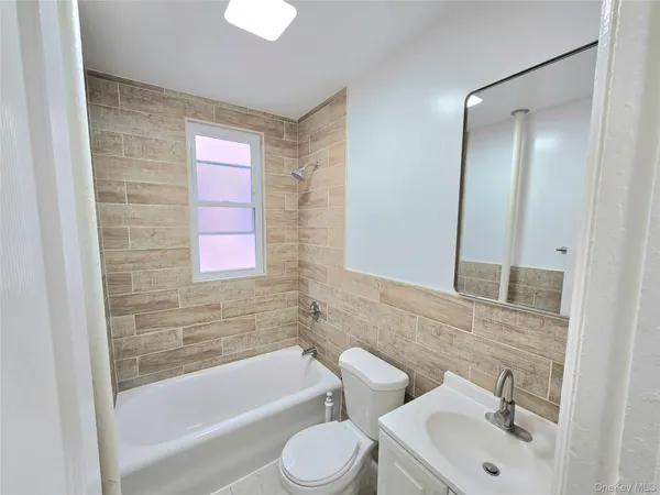 a bathroom with a bathtub shower sink vanity and toilet