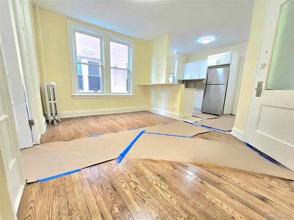 a view of a kitchen with a sink and dishwasher with wooden floor