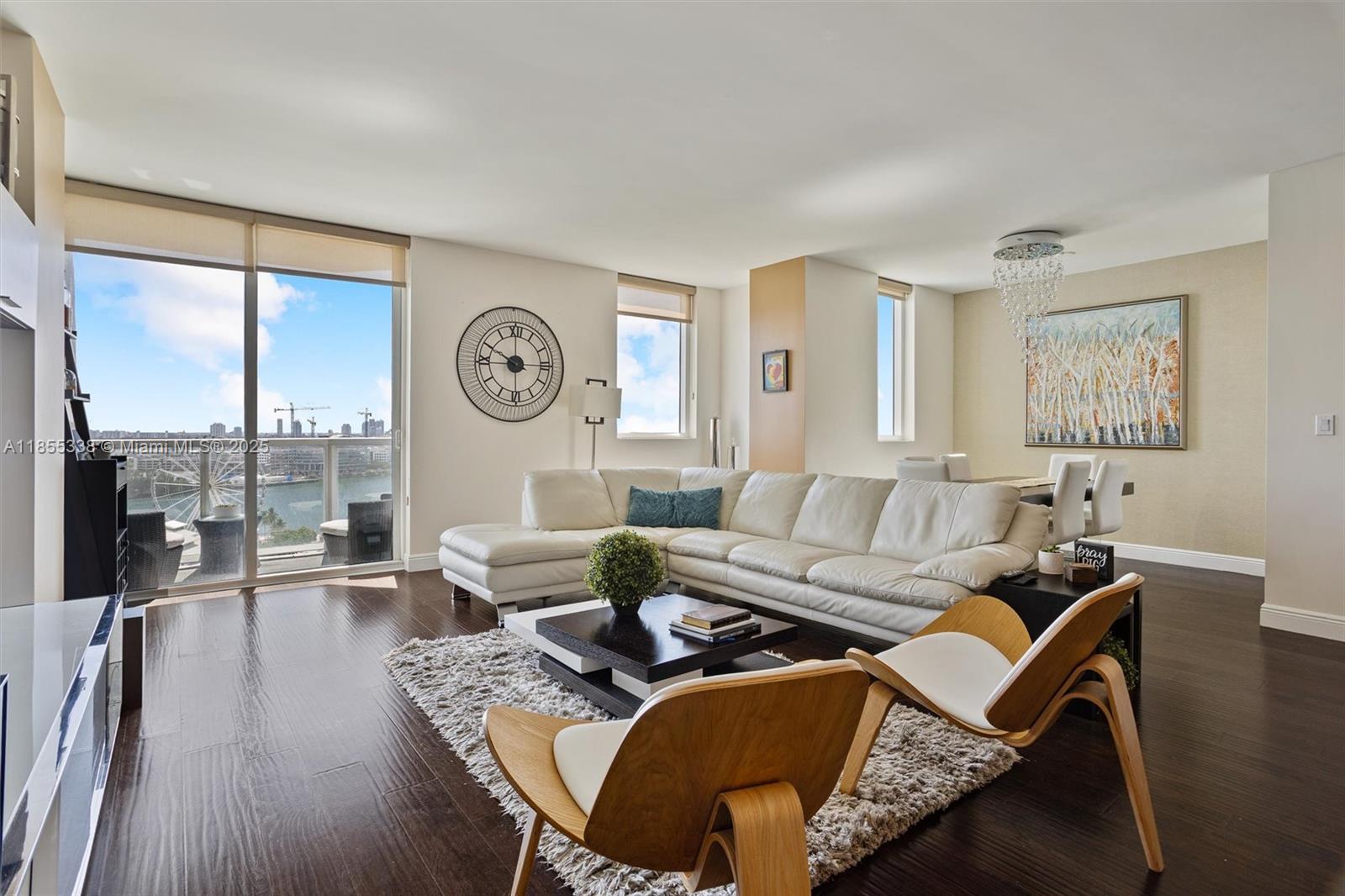 a living room with furniture a large window and wooden floor
