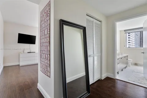 a view of a livingroom with wooden floor and a flat screen tv