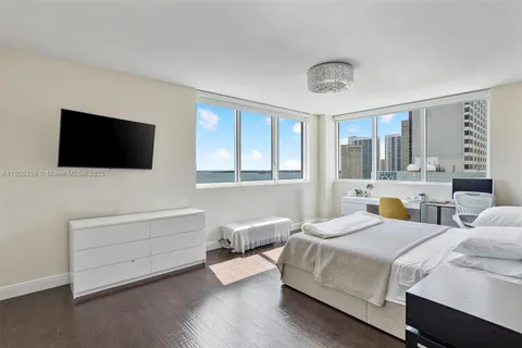 a bedroom with bed and a flat screen tv