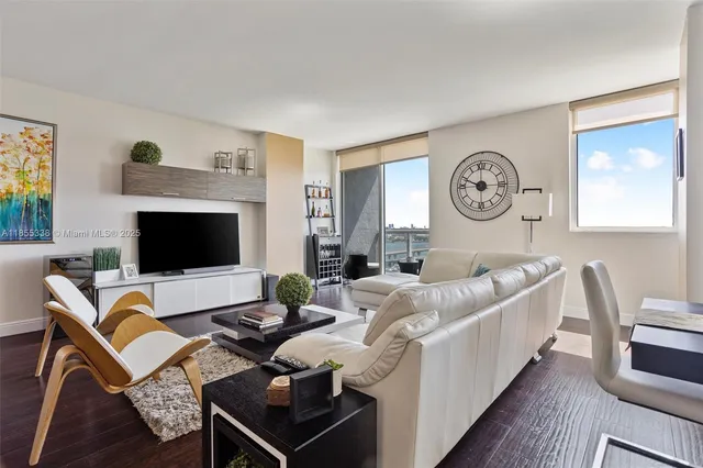 a living room with furniture a flat screen tv and a fireplace