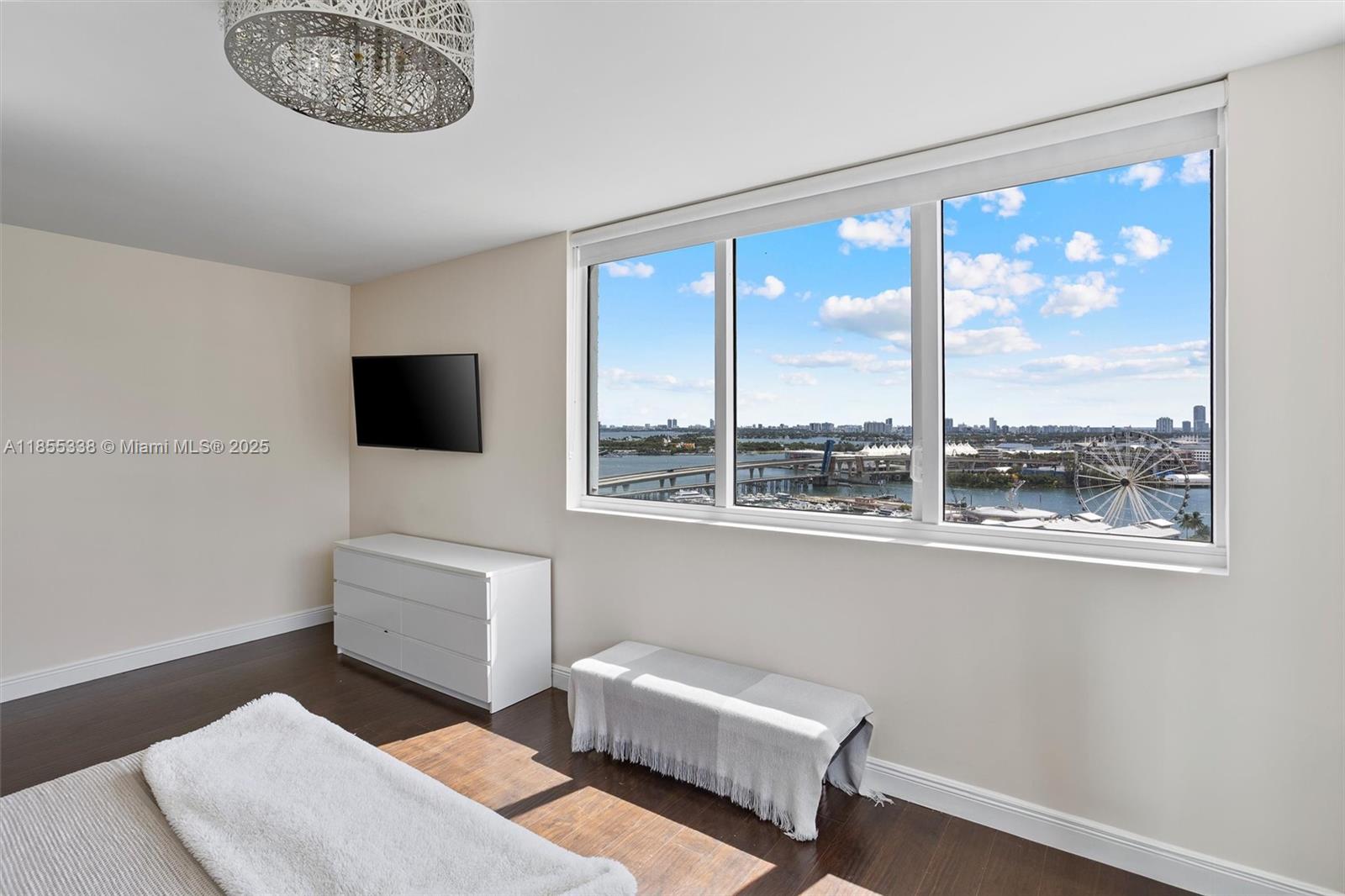 244 Biscayne Boulevard, Unit 1803 Miami, FL 33132 - Photo 22 of 38 a living room with furniture a flat screen tv and a window
