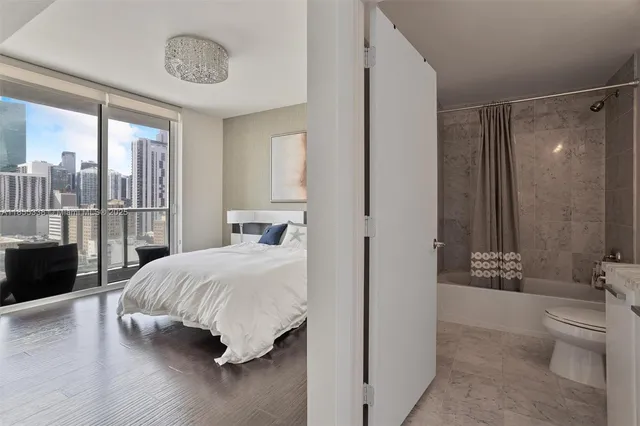 a bedroom with a large bed and a chandelier