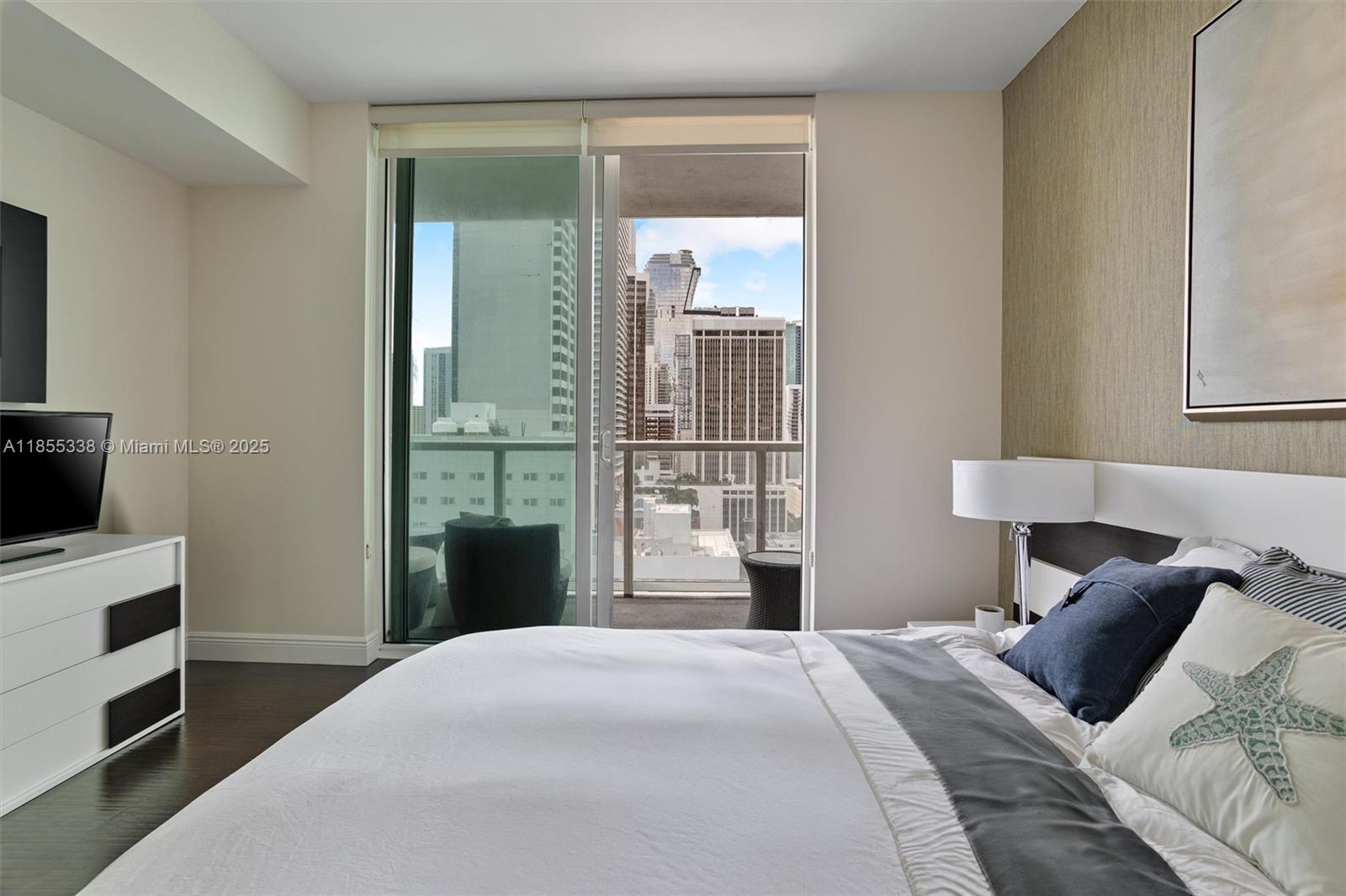 244 Biscayne Boulevard, Unit 1803 Miami, FL 33132 - Photo 29 of 38 a bedroom with a bed and a television
