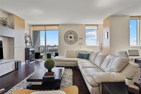 a living room with furniture a clock on wall and a window