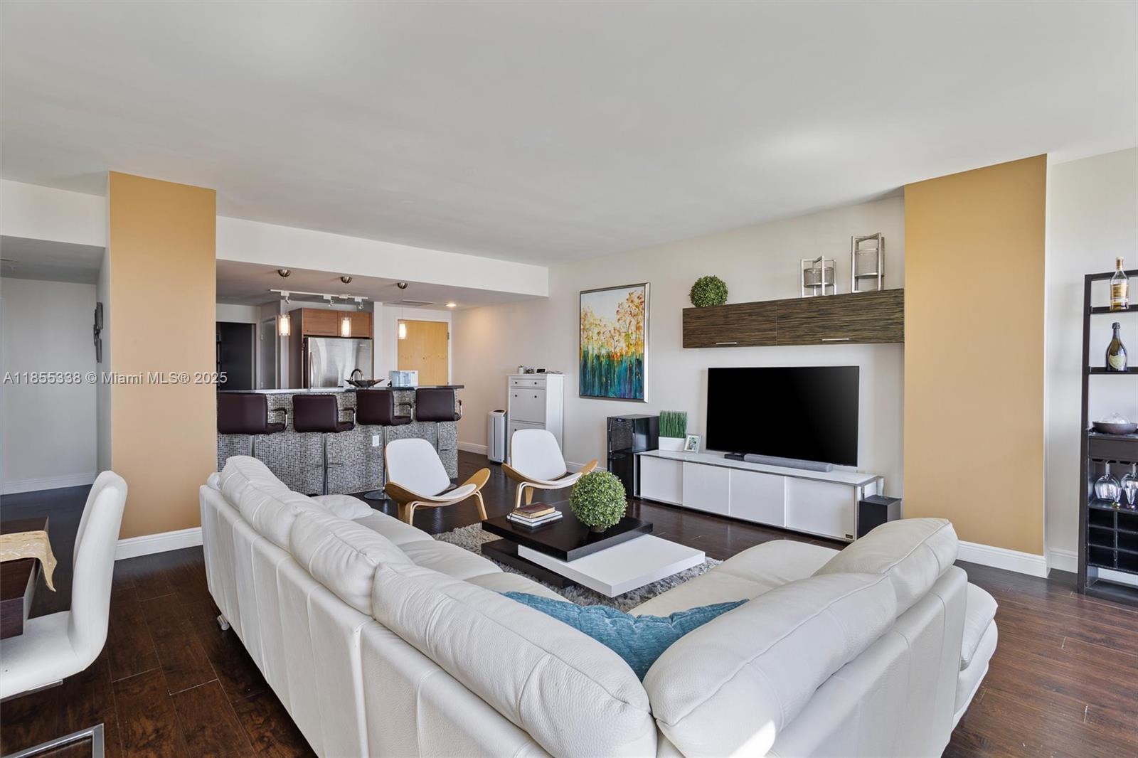 244 Biscayne Boulevard, Unit 1803 Miami, FL 33132 - Photo 5 of 38 a living room with furniture a flat screen tv and a fireplace