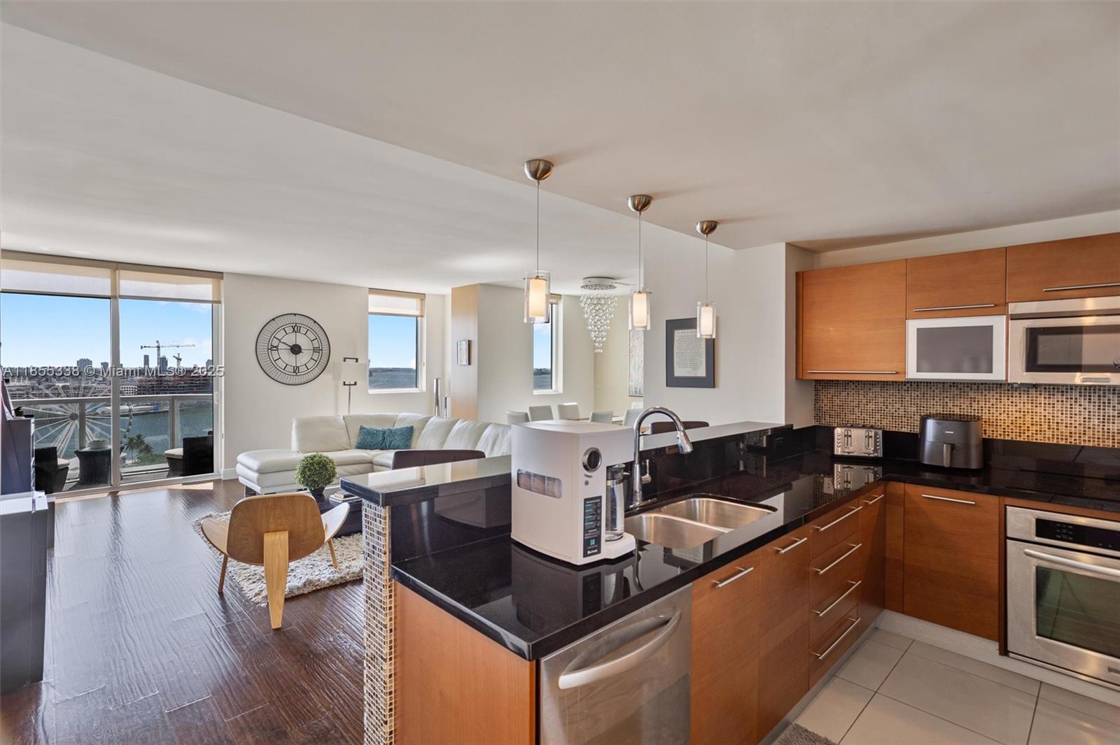 244 Biscayne Boulevard, Unit 1803 Miami, FL 33132 - Photo 6 of 38 a living room with granite countertop a couch a dining table and chairs