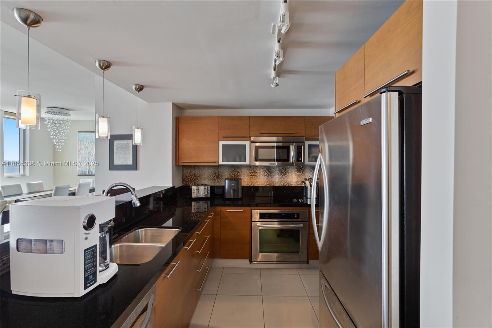 244 Biscayne Boulevard, Unit 1803 Miami, FL 33132 - Photo 7 of 38 a kitchen with kitchen island a counter top space a sink stainless steel appliances and cabinets
