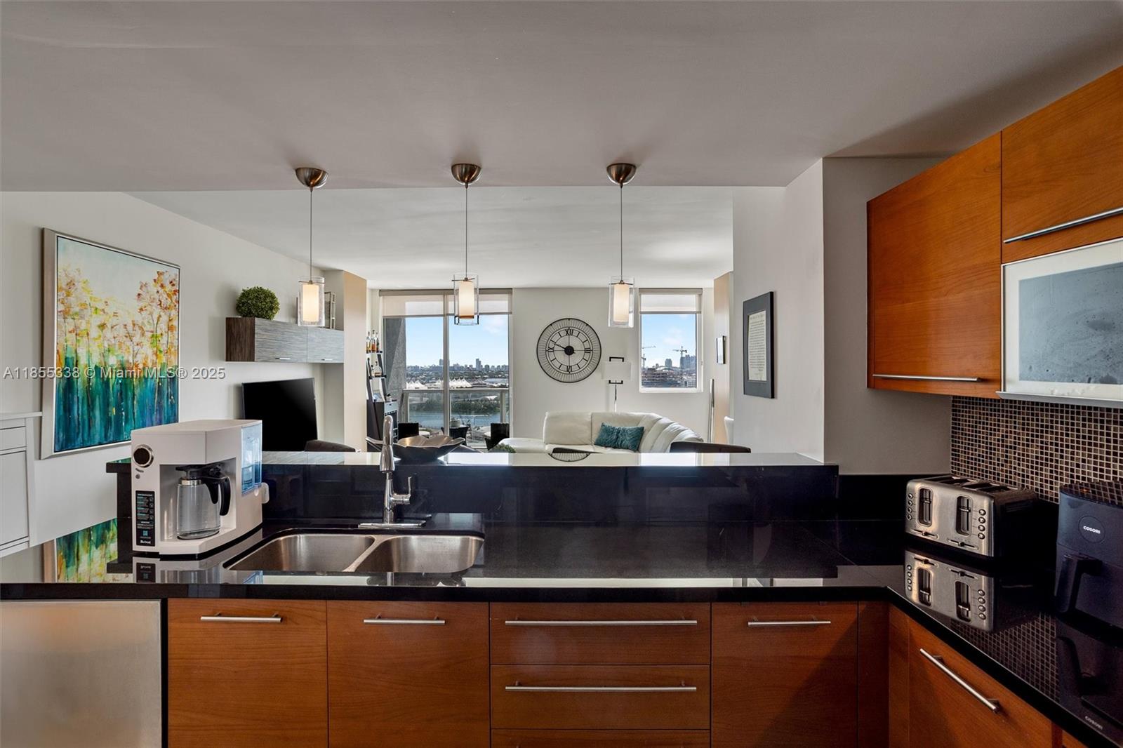 244 Biscayne Boulevard, Unit 1803 Miami, FL 33132 - Photo 8 of 38 a kitchen with kitchen island granite countertop a sink cabinets and stainless steel appliances