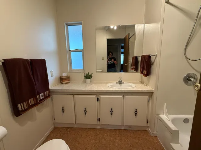 a living room with furniture a lamp and a window